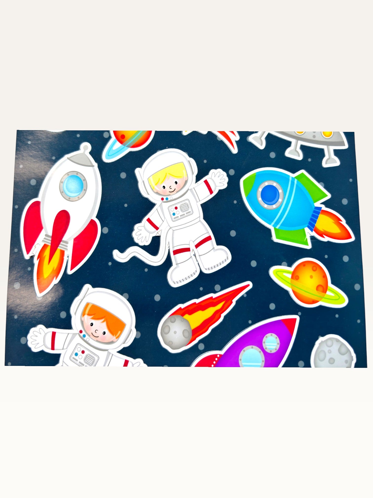Paper Party Studio glossy sticker sheet featuring colorful rockets, astronauts, and planets on a starry blue background