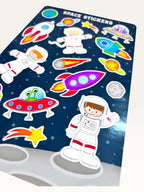 Paper Party Studio glossy sticker sheet featuring colorful rockets, astronauts, and aliens on a starry blue background.