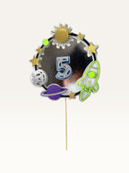 Paper Party Studio space-themed number 5 cake topper with silver foil ring, rocket, planets, and stars on a pick.