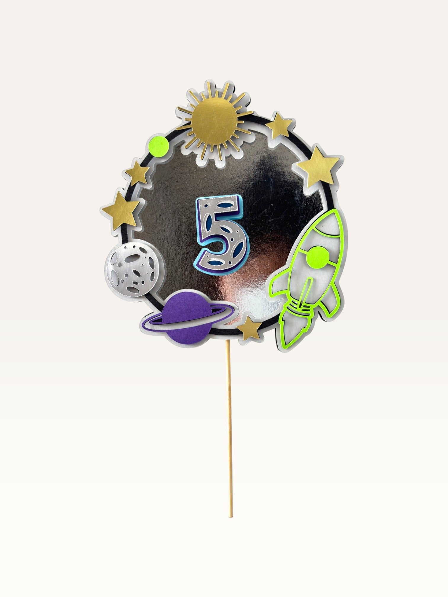 Paper Party Studio space-themed number 5 cake topper with silver foil ring, rocket, planets, and stars on a pick.