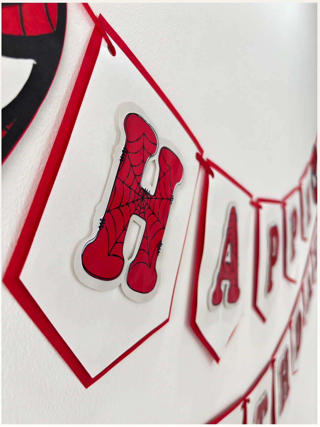 Paper Party Studio red and white swallowtail Happy Birthday banner with black spider-web letter detailing