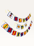 Paper Party Studio superhero birthday banner with comic book style flags in red, blue, and yellow for a first party.