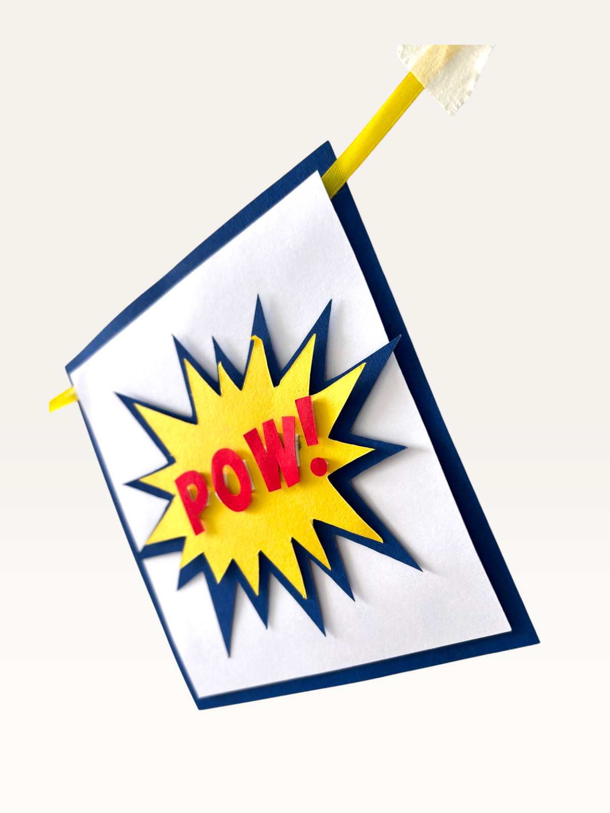 Paper Party Studio superhero comic burst POW flag in red, yellow, and navy blue with a dimensional layered design.