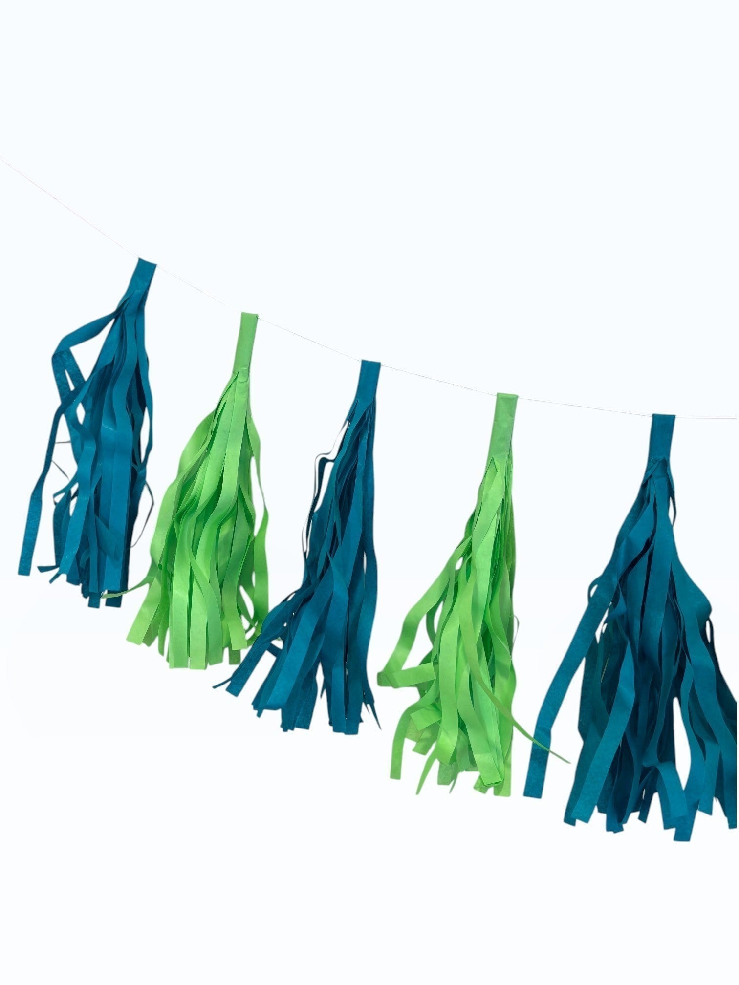 Paper Party Studio handmade tissue paper tassel garland in alternating teal and lime green for party decor.