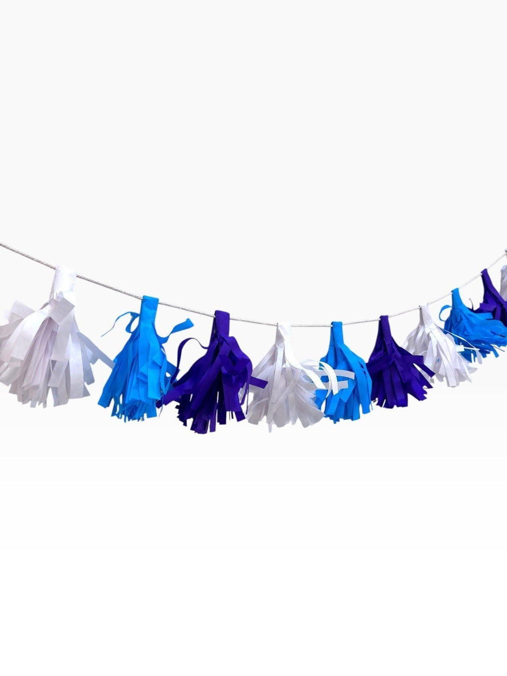 Paper Party Studio handmade tissue paper tassel garland in blue, purple, and white for party decorations.