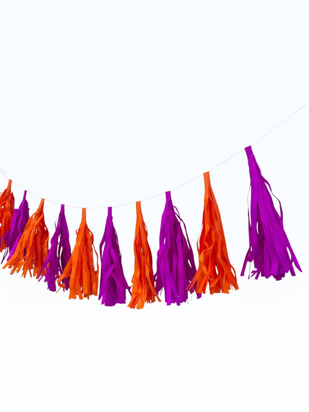 Paper Party Studio handmade tissue paper tassel garland in vibrant orange and purple for party decor.