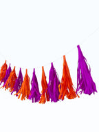 Paper Party Studio handmade tissue paper tassel garland in vibrant orange and purple for party decoration.