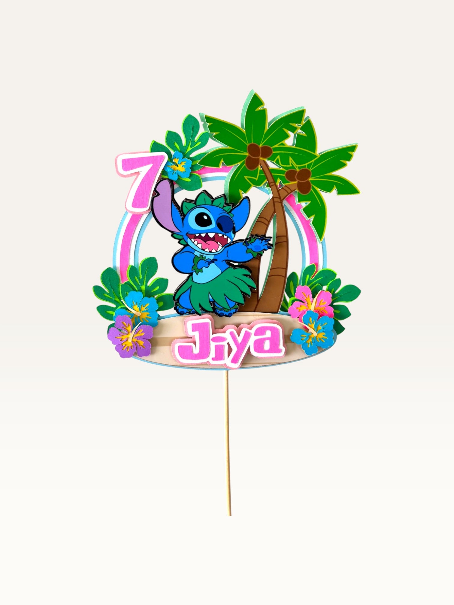Paper Party Studio personalised tropical luau cake topper featuring a blue alien, palm trees, and hibiscus flowers.