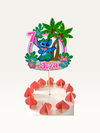 Paper Party Studio personalised tropical luau cake topper featuring a blue alien, palm trees, hibiscus, and age seven.