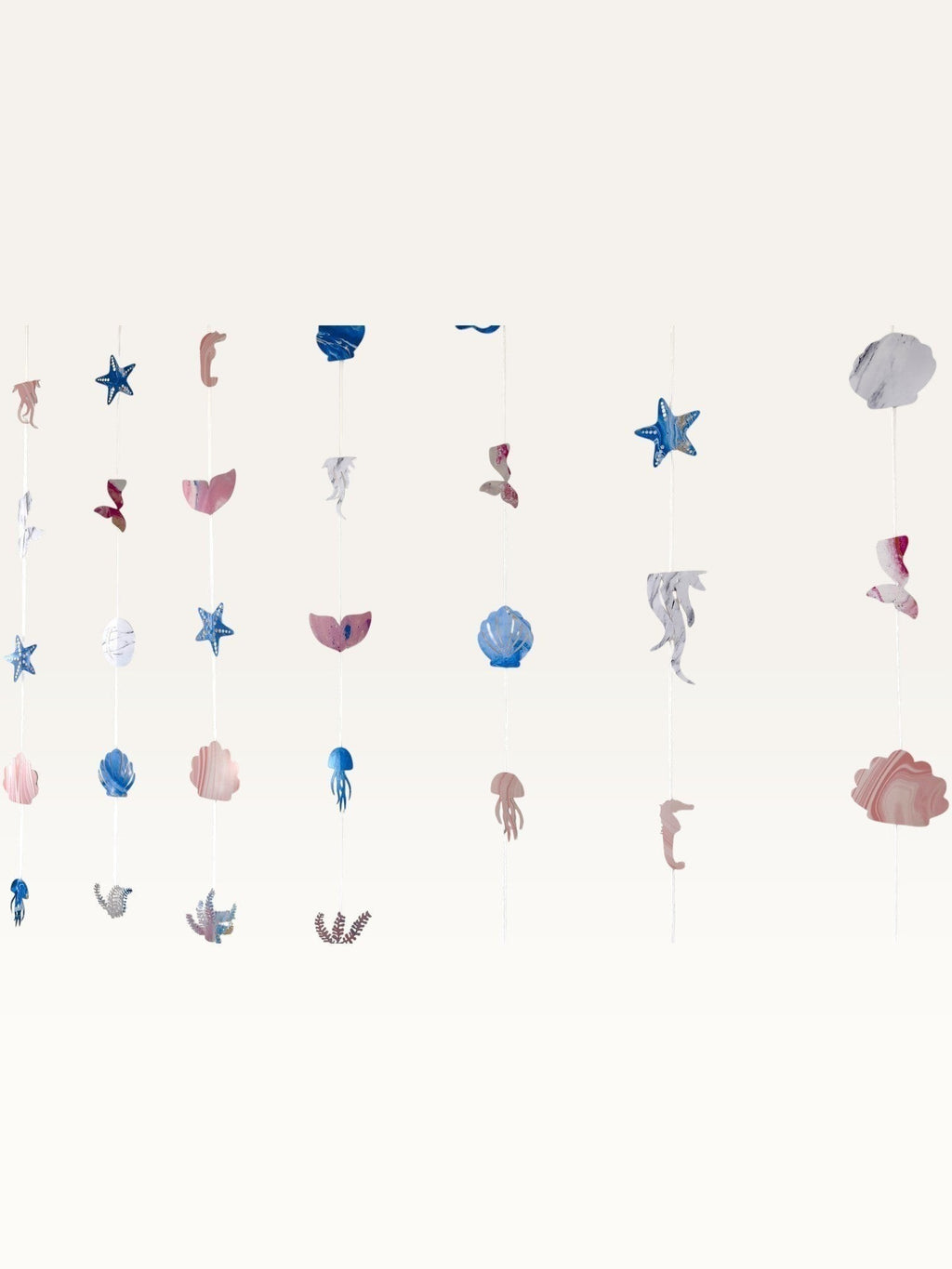 Paper Party Studio under the sea backdrop with hanging strings of cardstock shells, starfish, and mermaid tails.