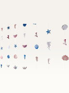 Paper Party Studio under the sea backdrop with hanging strings of cardstock shells, starfish, and mermaid tails.