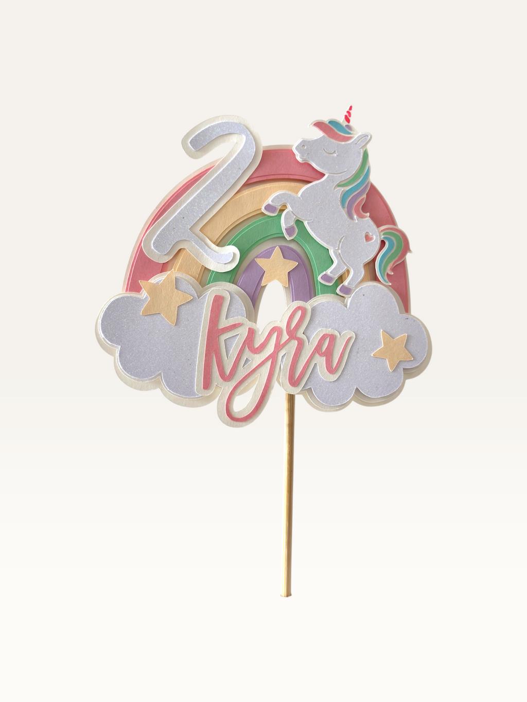 Paper Party Studio personalised unicorn cake topper with pastel rainbow and clouds