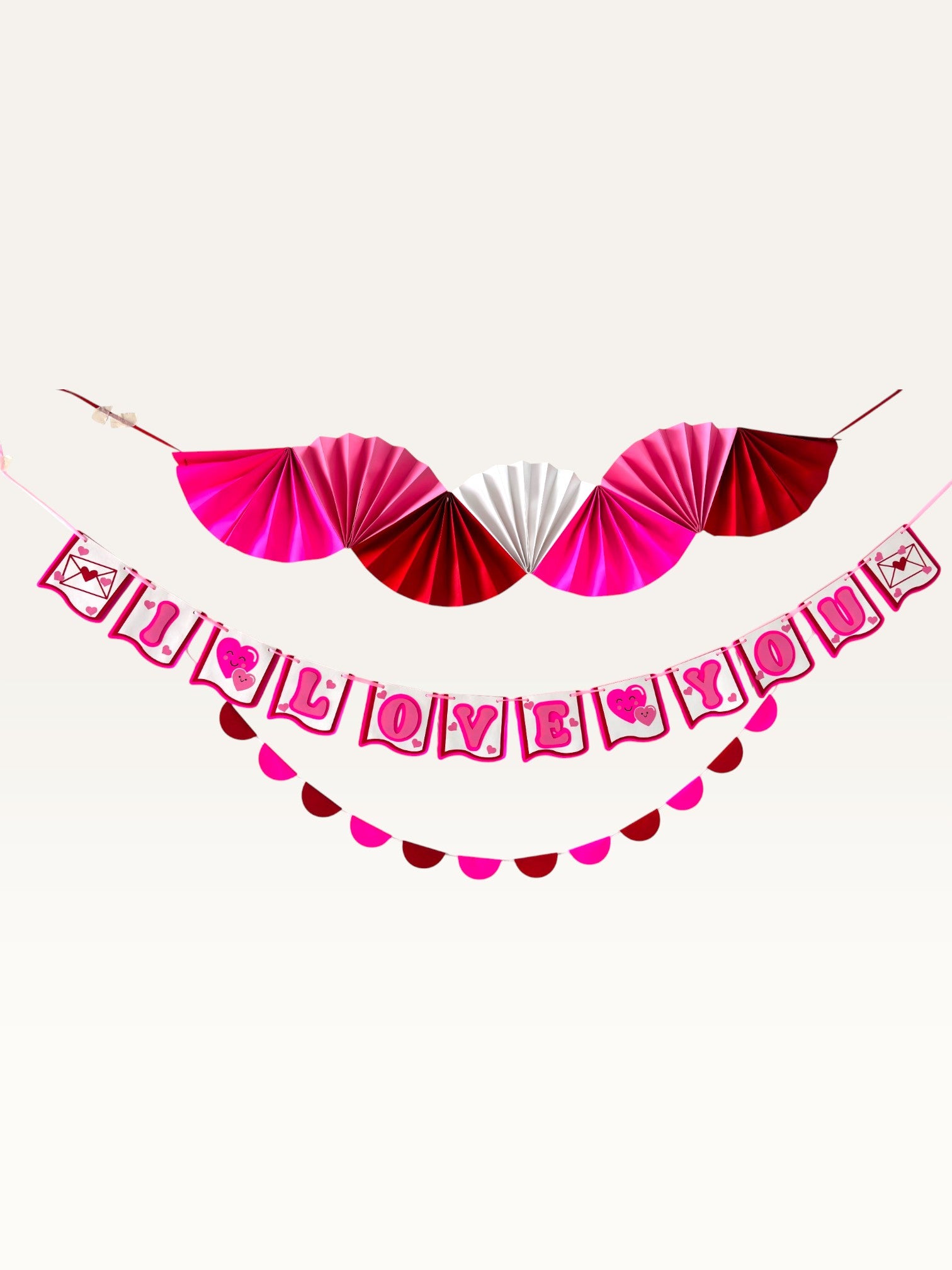 Paper Party Studio Valentine's decoration set with a pink and red paper fan backdrop, I Love You banner, and garland.