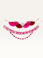 Paper Party Studio Valentine's decoration set featuring a pink, red, and white fan, I Love You banner, and garland.