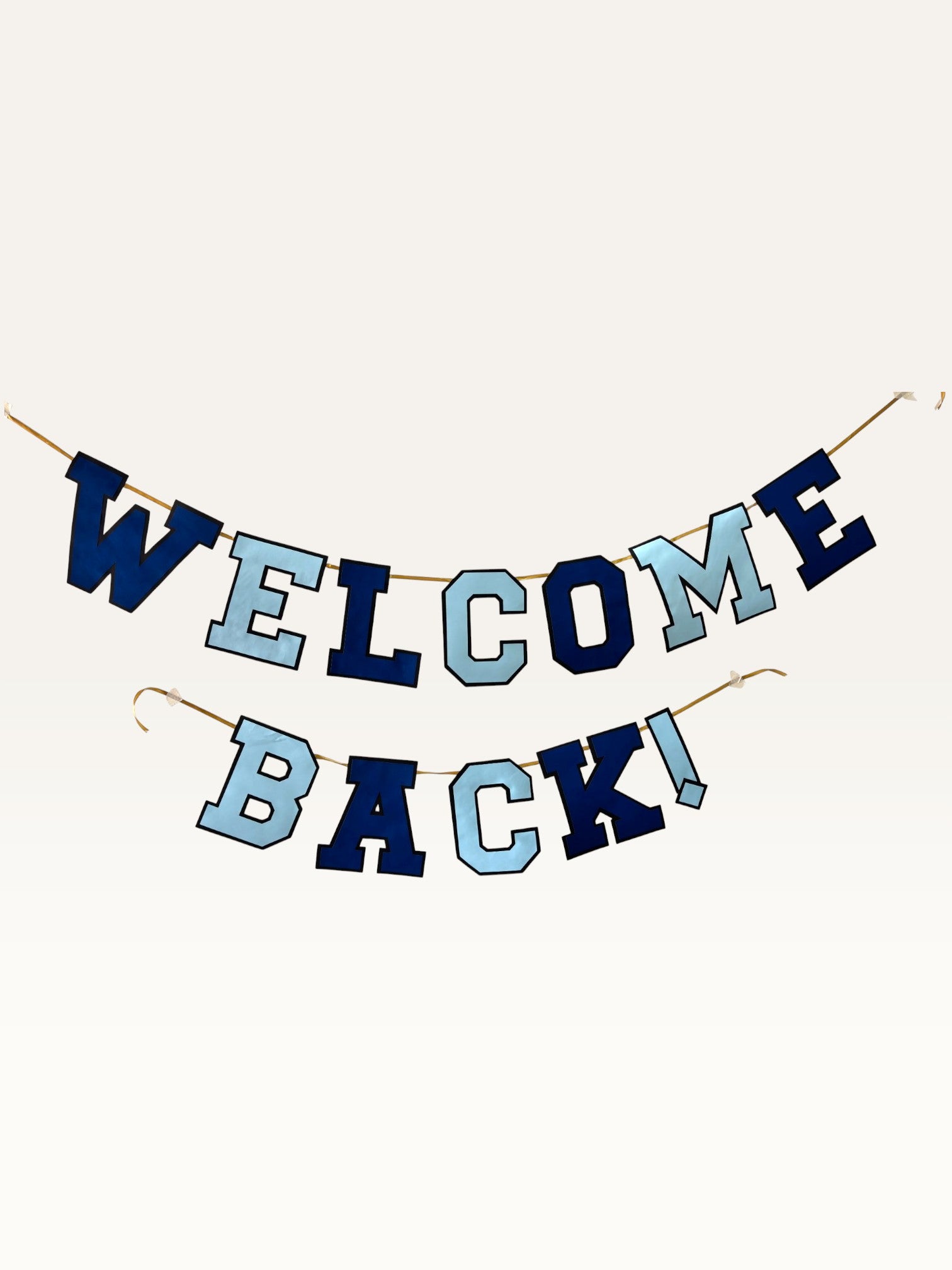 Paper Party Studio Welcome Back banner in navy and sky blue varsity letters strung on a gold cord.