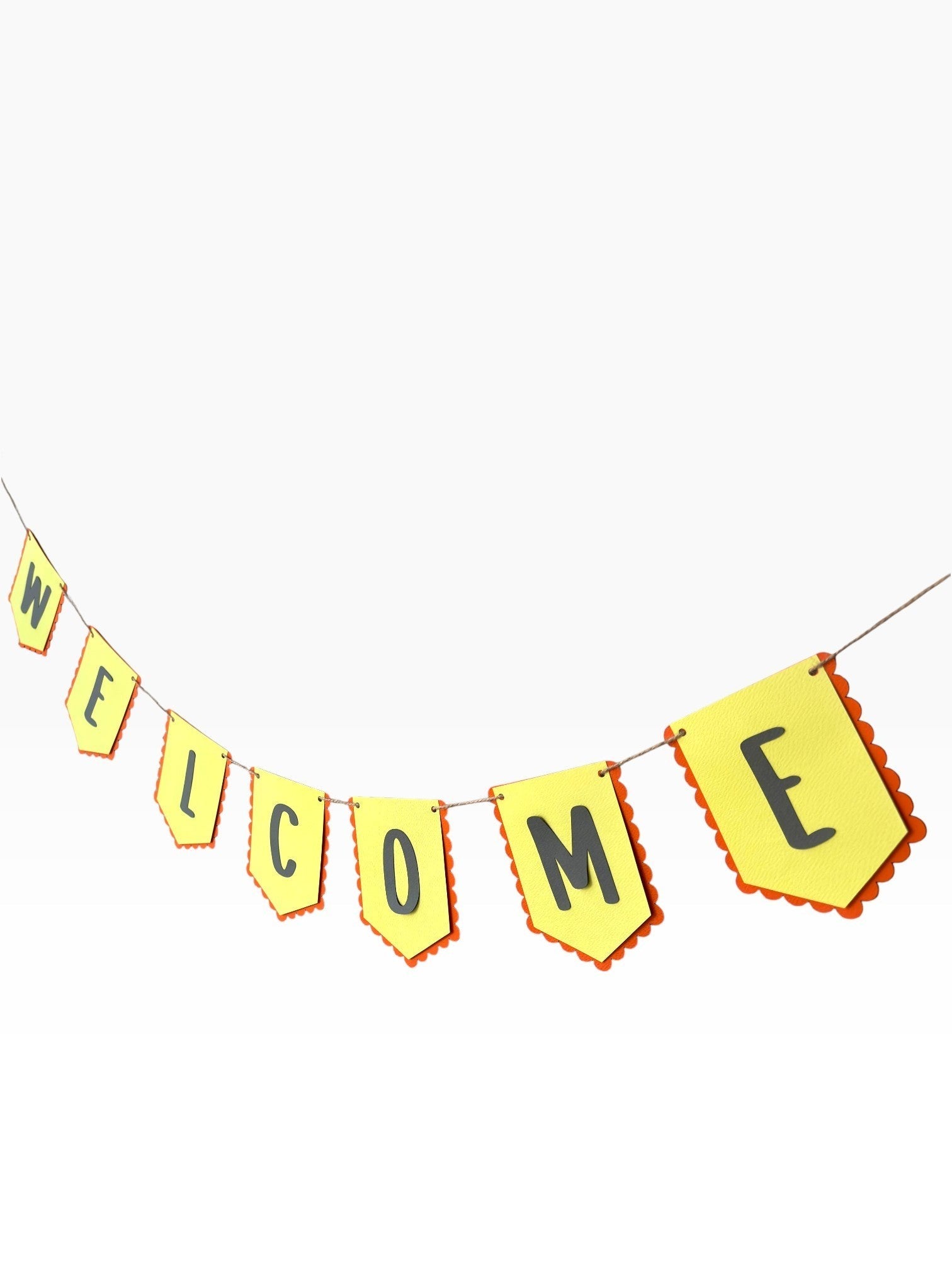 Paper Party Studio yellow paper bunting with scalloped red edges spells out WELCOME in black letters.