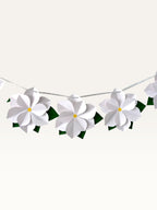 Paper Party Studio white 3D paper flower garland with yellow centers and green leaves on a silver cord for decor