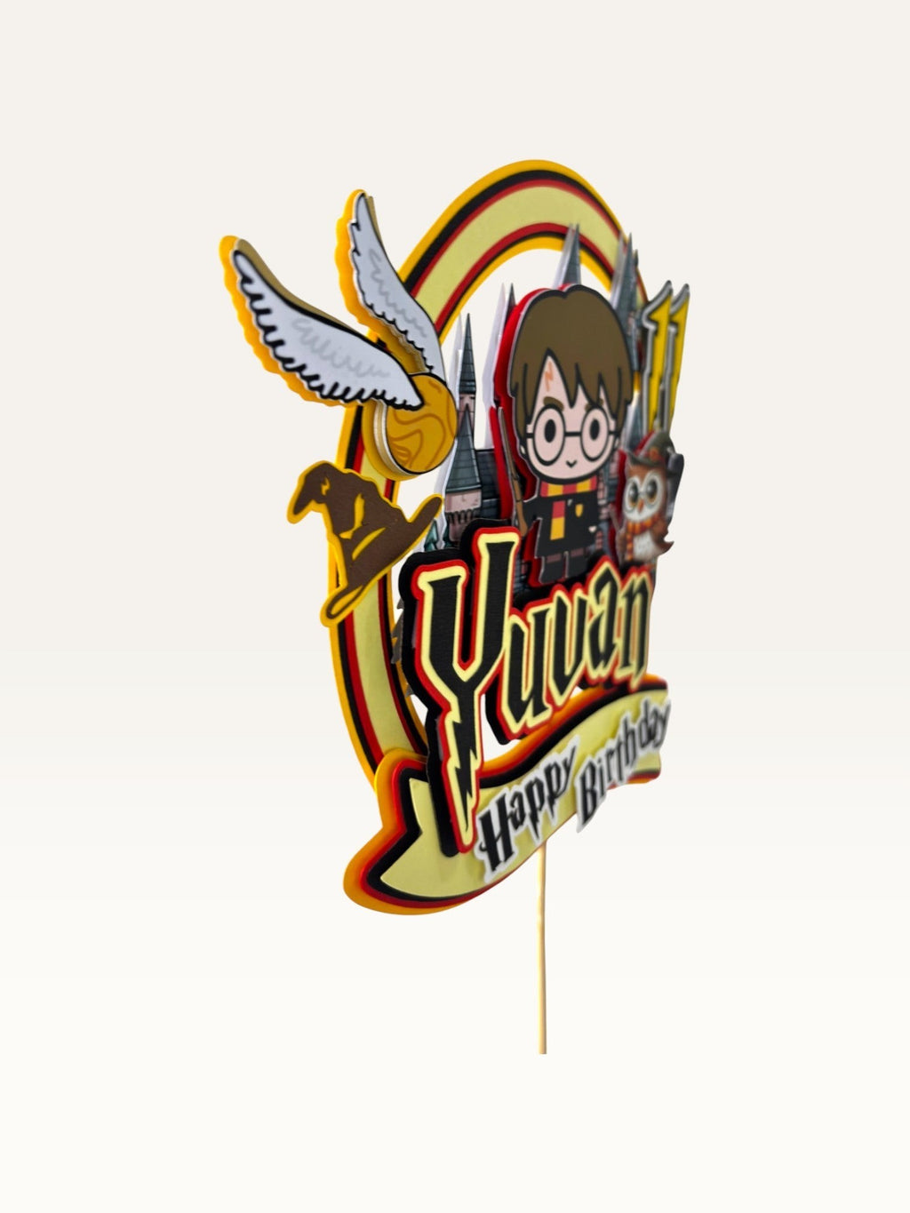 Paper Party Studio personalised wizard school cake topper with a young wizard, owl, and castle in red and gold.