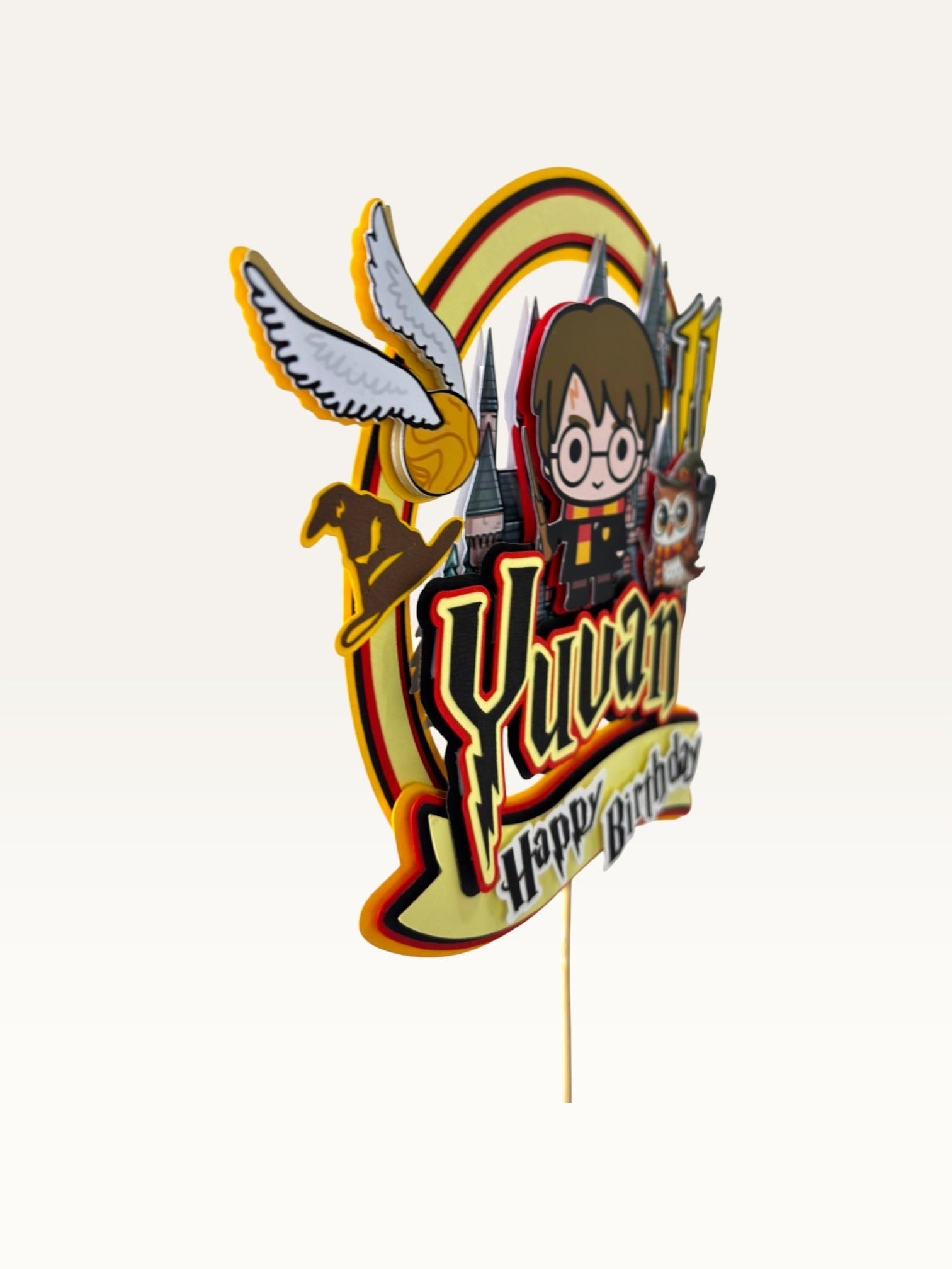 Paper Party Studio personalised wizard school cake topper with a young wizard, owl, and castle in red and gold.