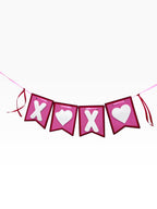 Paper Party Studio XOXO banner with white X and heart cut-outs on pink flags, red trim, and satin ribbon ties.