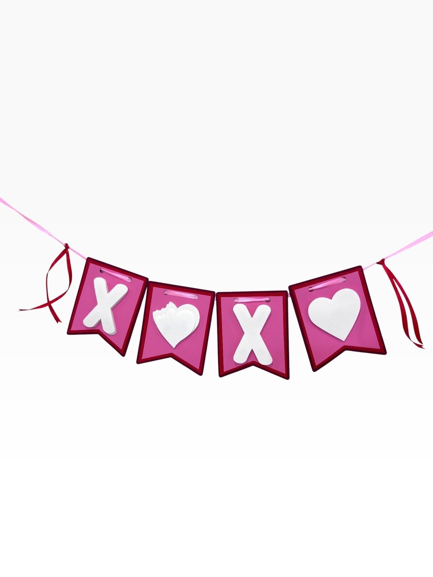 Paper Party Studio XOXO banner with white X and heart cut-outs on pink flags, red trim, and satin ribbon ties.