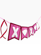 Paper Party Studio XOXO banner with pink flags, white layered letters, and heart cut-outs, tied with red satin ribbon.