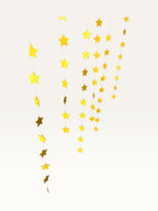 Paper Party Studio set of 10 yellow paper star garland strings for party decorations and ceiling backdrops.